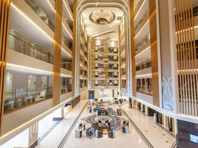 Luxurious hotel atrium with golden accents and seating area in the center