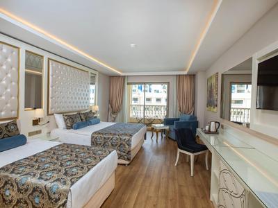 Modern hotel room with two beds, wooden floor, and large window.