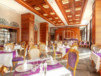 Elegant restaurant with wooden ceiling, white tablecloths, and purple table runners.