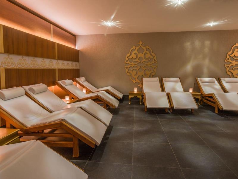 Relaxation room with multiple cushioned loungers and warm, soft lighting