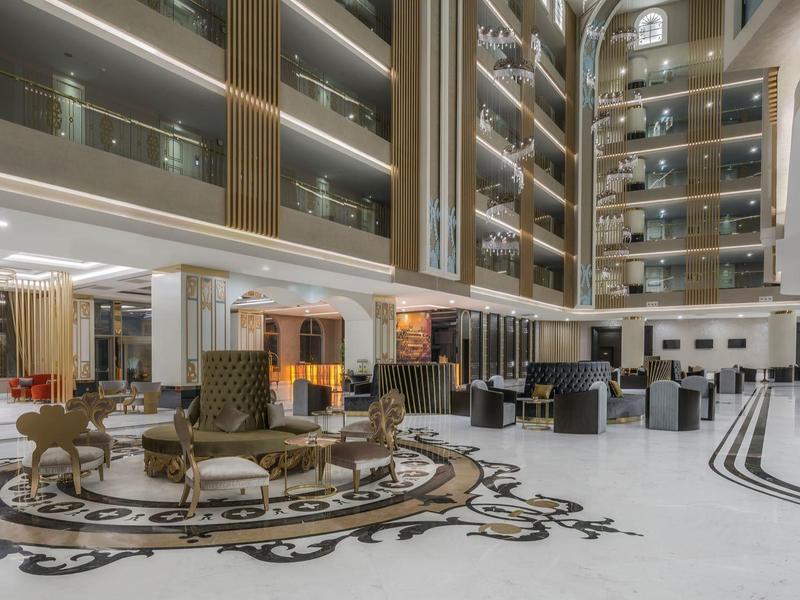Luxurious hotel lobby with elegant fireplace, decorative seating areas, and modern interior design.