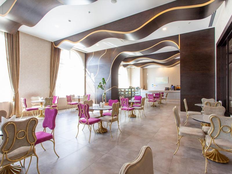 Bright, modern dining area with decorative chairs and wave-shaped ceiling.