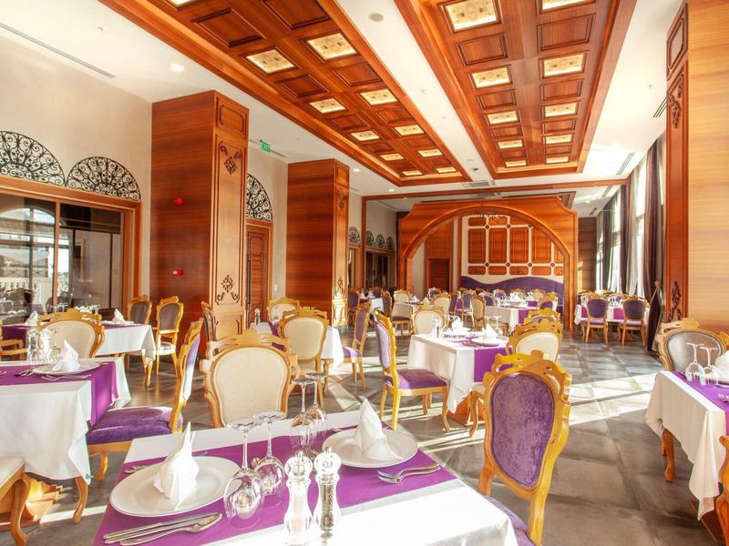 Elegant restaurant with wooden ceiling, white tablecloths, and purple table runners.