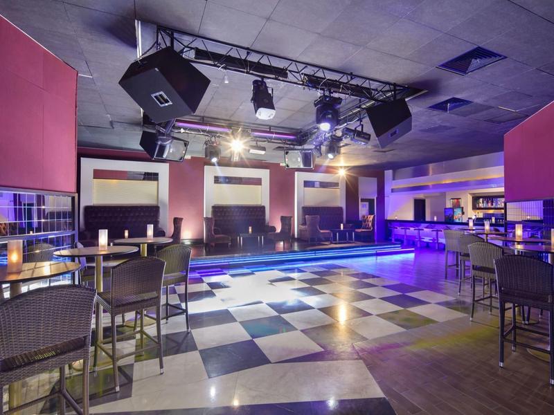 Nowoczesny pusty bar hotelowy z oświetleniem LED i krzesłami przy wysokich stolikach