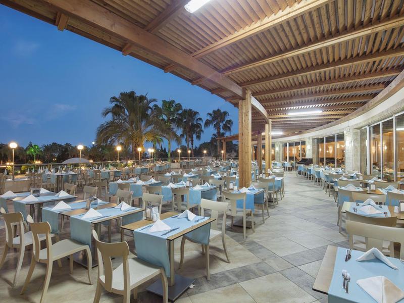 Restauracja na świeżym powietrzu z nakrytymi stołami pod zadaszonym tarasem o zmierzchu