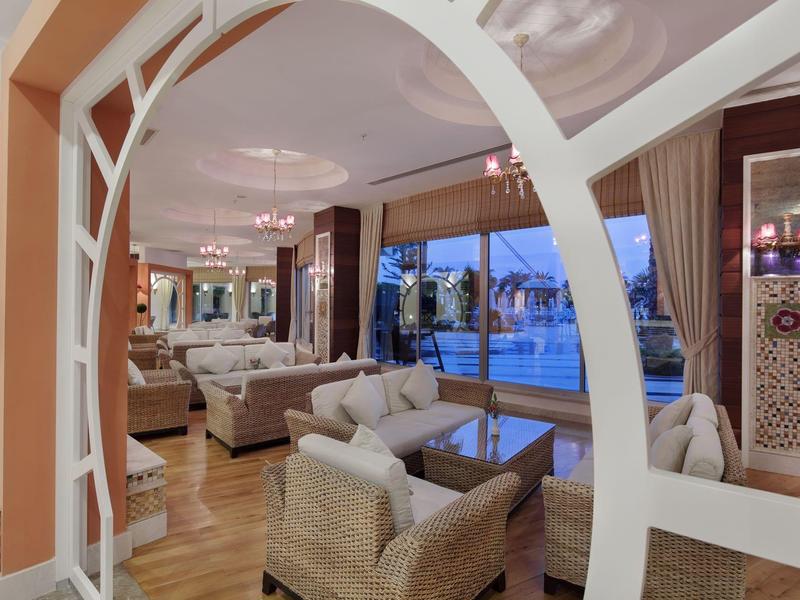 Elegancka przestrzeń wypoczynkowa hotelu z wygodnymi miejscami do siedzenia i widokiem na basen o zmierzchu.