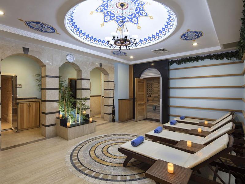 Elegancki pokój relaksacyjny spa z drewnianymi leżakami i artystycznie malowaną kopułą w hotelu.