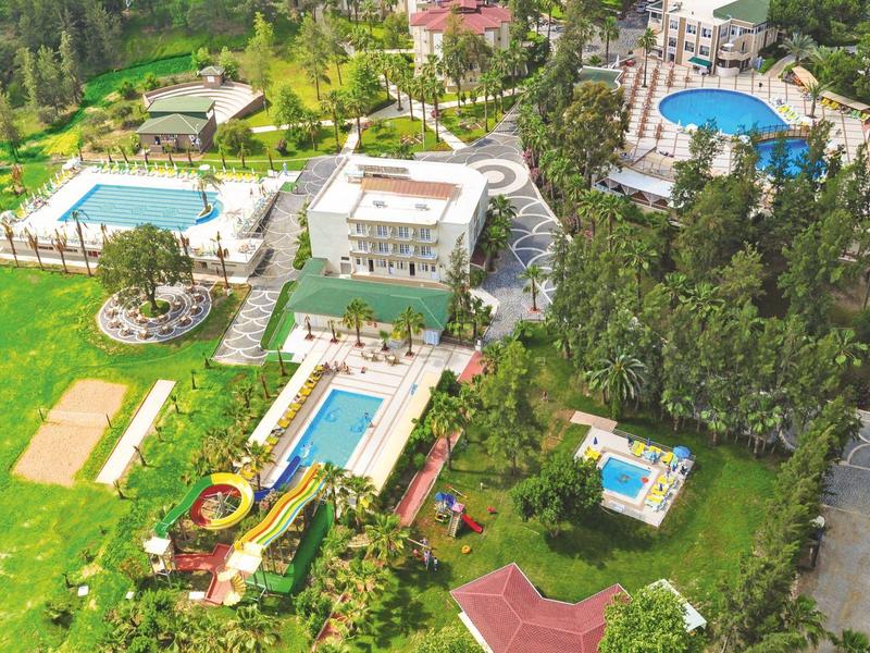 Aerial view of a hotel featuring multiple swimming pools and green spaces.