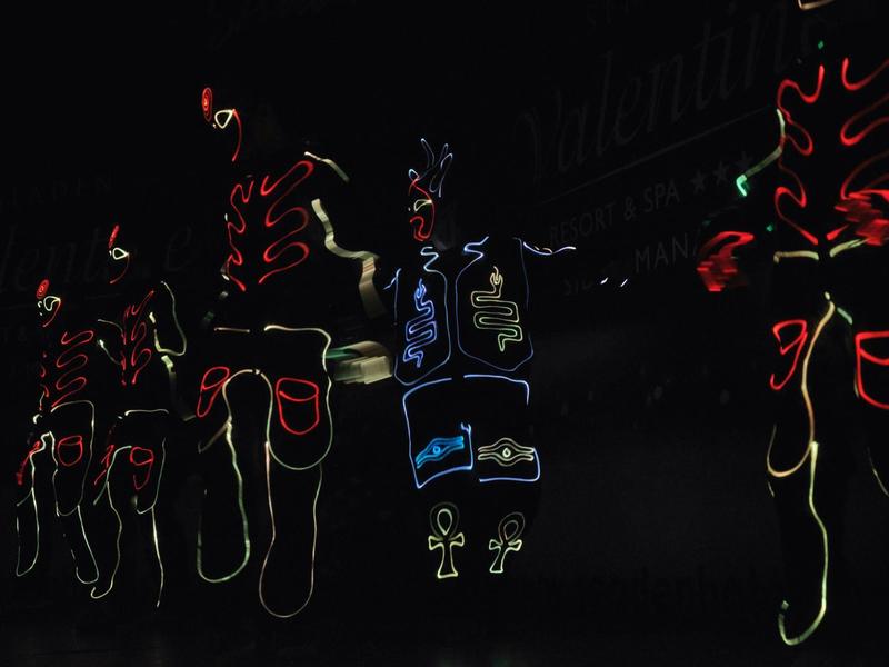 Tancující lidé s neonovými světly na tmavém pozadí