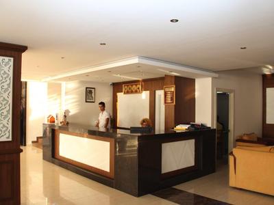 Modern reception area with front desk and seating under warm lighting.