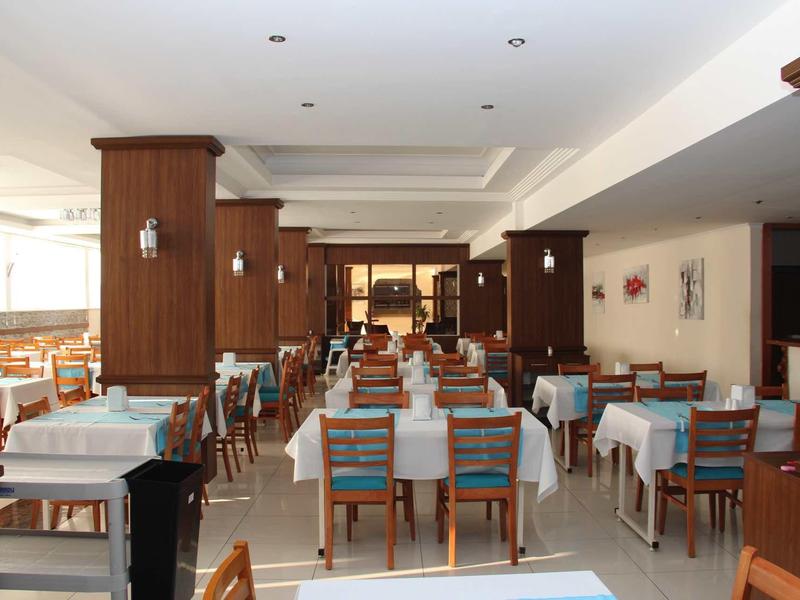 Elegant restaurant with wooden furniture and set tables in a bright room.