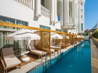 Zona piscina di lusso con lettini e ombrelloni in un elegante hotel