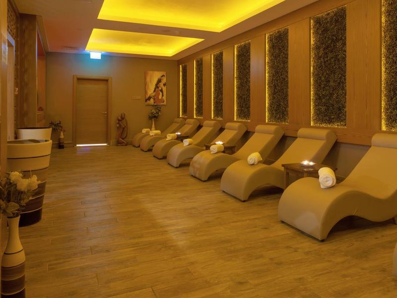 Ein entspannter Ruheraum mit bequemen Liegen, warmem Licht und Holzfußboden.