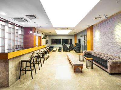 Area lounge moderna dell'hotel con bar, sgabelli e comodi posti a sedere.