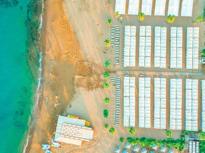 Luchtfoto van een hotel met zwembad aan het strand naast de zee