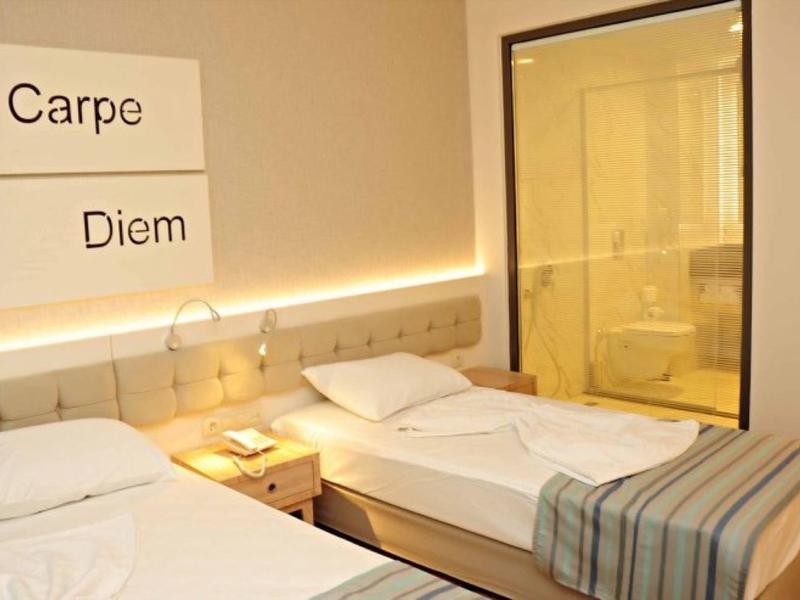 Camera d'hotel moderna con due letti e cabina doccia in vetro.