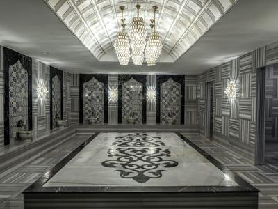 Luxusní pokoj s velkým kobercem a nástěnnými svítidly, vhodný pro hotel.
