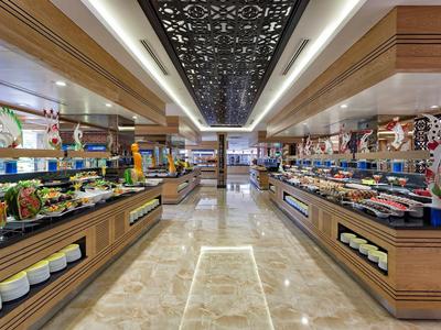 Large modern buffet area with diverse dishes and bright marble flooring