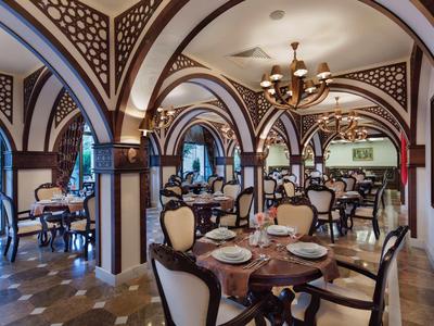 Elegant restaurant with vaulted ceilings, chandeliers, and classic wooden furniture.