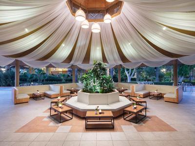 Elegant outdoor seating area with central plant arrangement under tent roof