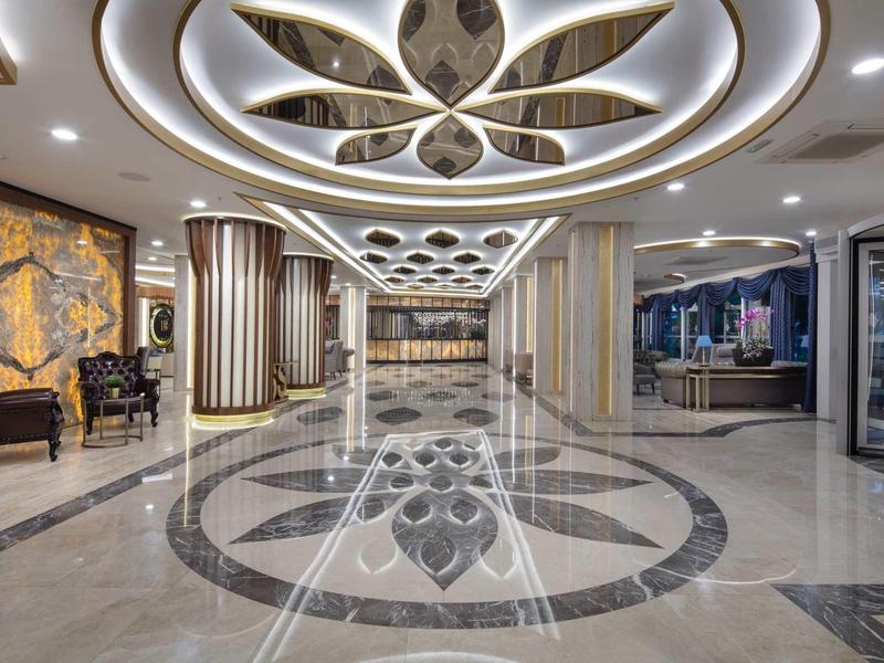 Modern hotel lobby area with artistic marble floor and ceiling decor.