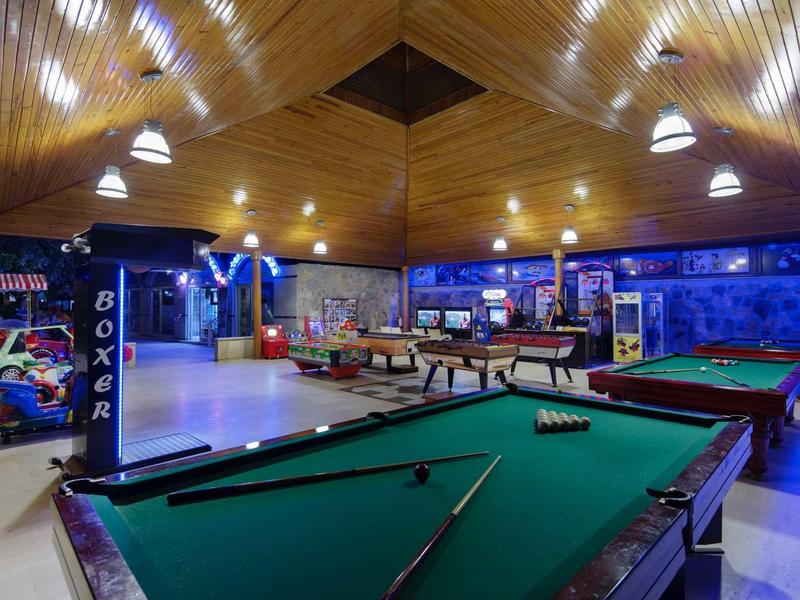 Large leisure room with pool tables, punching bag, and cozy lighting