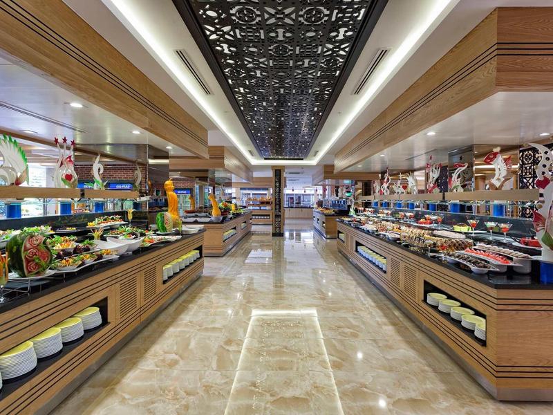 Large modern buffet area with diverse dishes and bright marble flooring