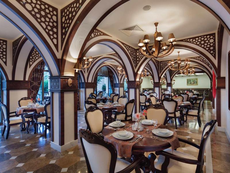 Elegant restaurant with vaulted ceilings, chandeliers, and classic wooden furniture.