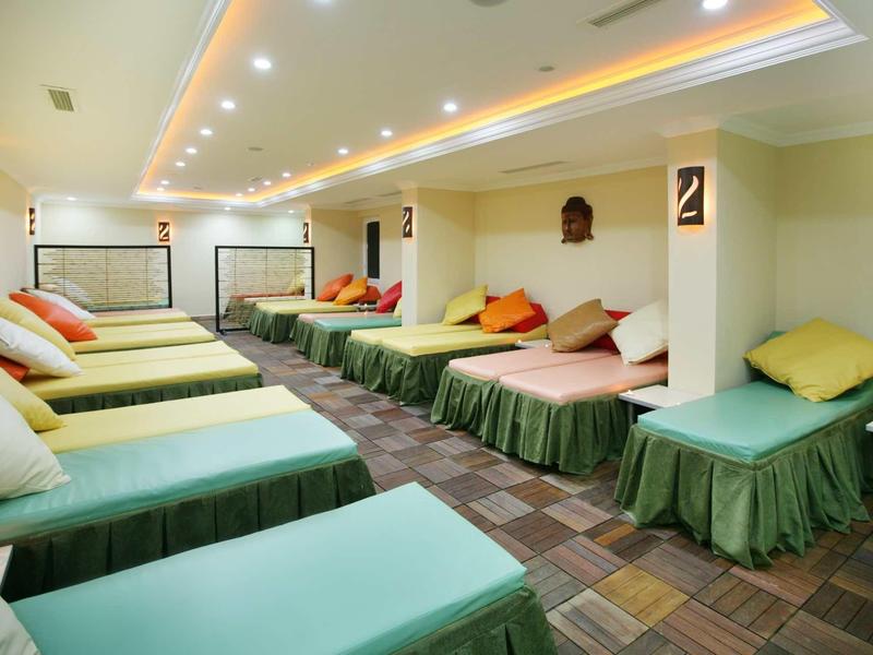 quiet relaxation area with multiple beds and pillows in a well-lit room