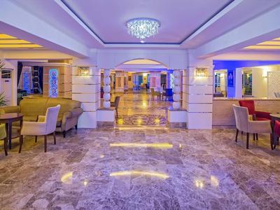 Heller Hotel-Lobby mit Marmorfußboden, gemütlichen Sesseln und dekorativer Beleuchtung.