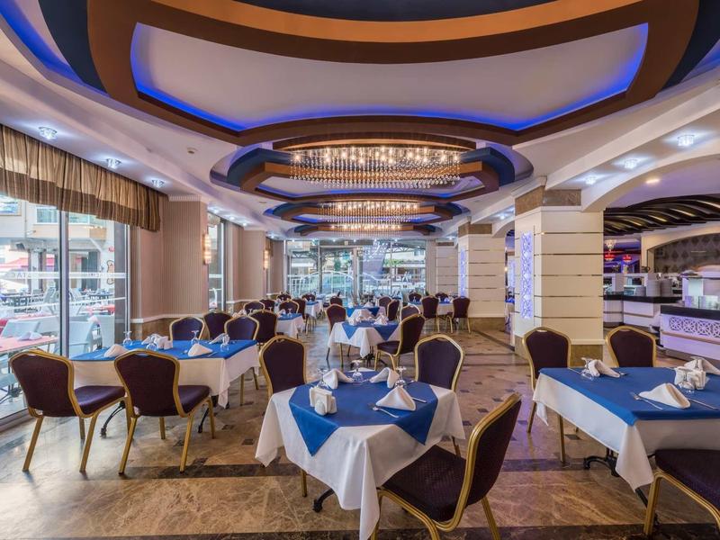 Spacious restaurant interior with blue and white table settings and modern ceiling design.