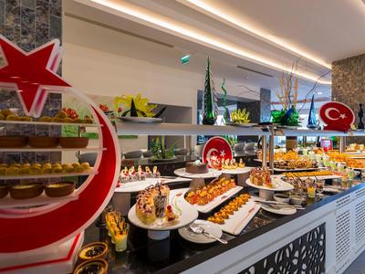 Buffet mit vielfältigen süßen und herzhaften Speisen dekoriert mit roten Halbmond- und Sternsymbolen.