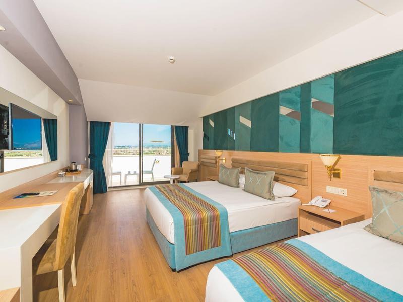 Modern hotel room with two beds and sea view.