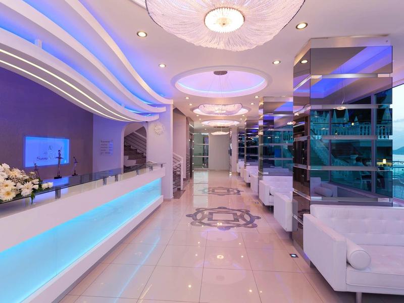 Světlá, moderní hotelová hala s lesklou podlahou a nepřímým osvětlením.