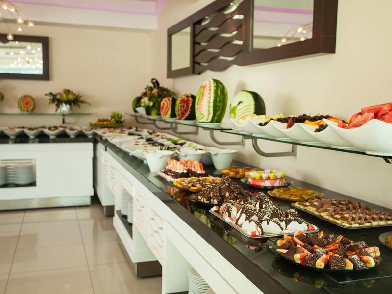 Bufet s různými dezerty a ovocem v hotelové restauraci.