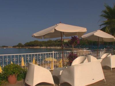 Terras met wit meubilair en parasols met uitzicht op zee bij heldere lucht