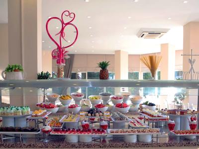Buffet con diversi piatti e dessert in un'area ristorante moderna.