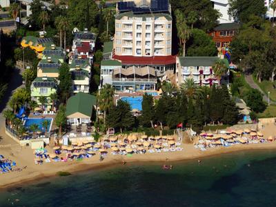 Strandhotel met zwembad, parasols en bomen bij het water