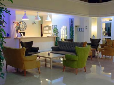 Modern ingerichte hotel lobby met kleurrijke fauteuils en receptiebalie.