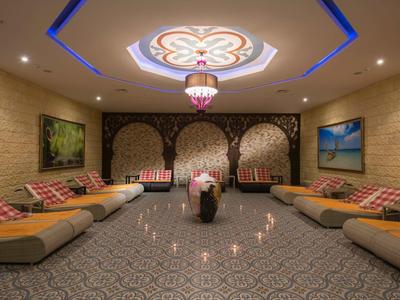 Sala relax elegante con comodi divani, arredamento orientale e illuminazione d'atmosfera.