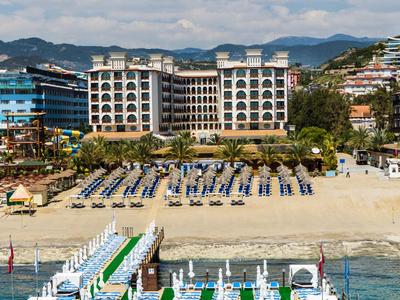 Edificio alberghiero sulla spiaggia con lettini e molo sul mare con tempo soleggiato