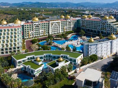 Velký hotelový resort s několika bazény a zahradami v venkovské oblasti.