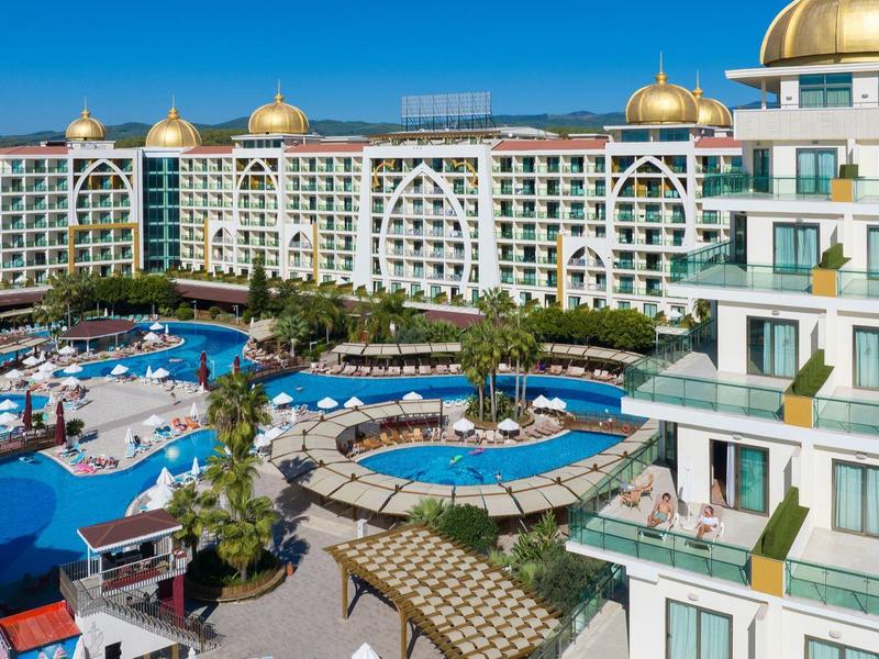 Velké hotelové středisko s několika bazény, slunečními terasami a zlatými kopulemi na střeše.