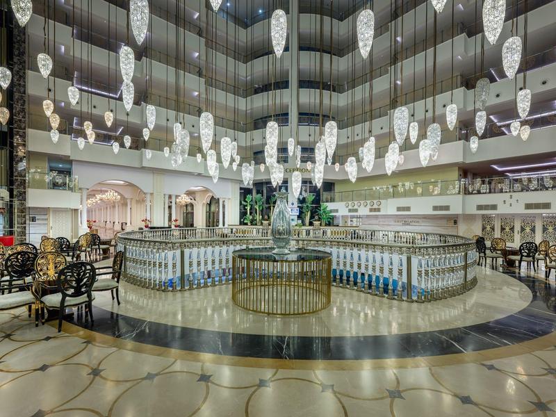 Prostorná hotelová hala s moderním osvětlením, sezeními a elegancí.