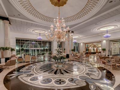 Großer, eleganter Hotellobby mit marmorboden, Kronleuchtern und bequemen Sitzgruppen.