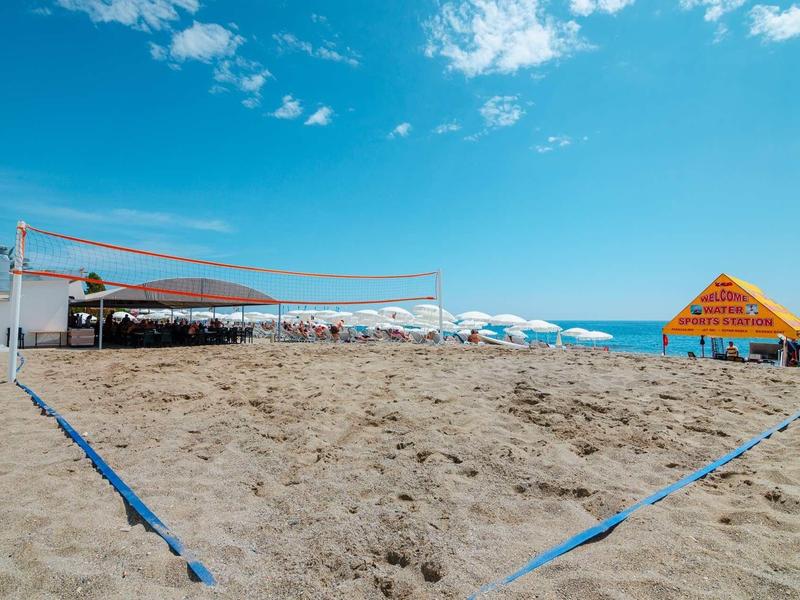 Plážové volejbalové hřiště sítě v slunečný den na pláži s výhledem na moře.