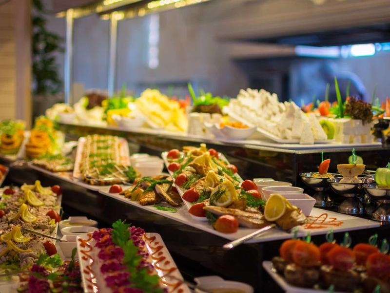 Bufetový stůl s širokou škálou čerstvých pokrmů a salátů v hotelu