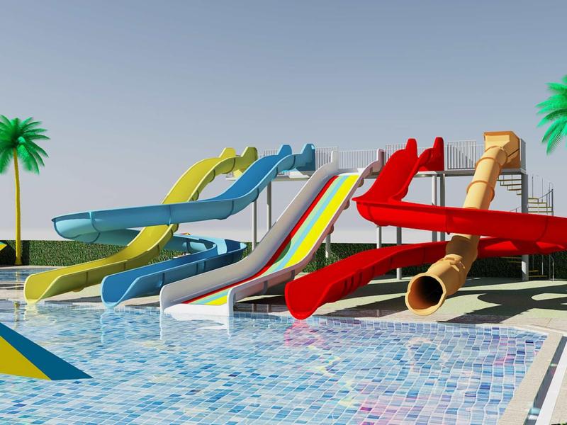 Několik barevných vodních skluzavek vede do bazénu pod čistou modrou oblohou.