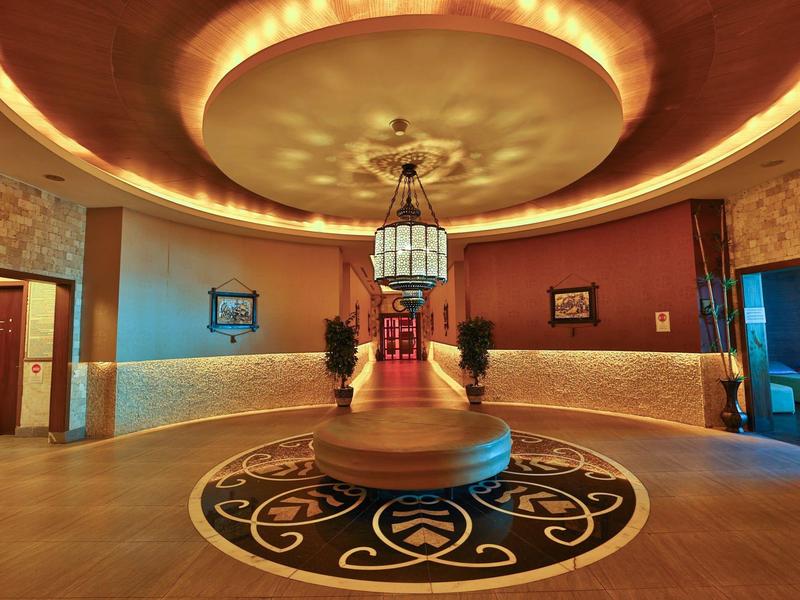 Salón lujoso con iluminación cálida, muebles clásicos y detalles decorativos elegantes.