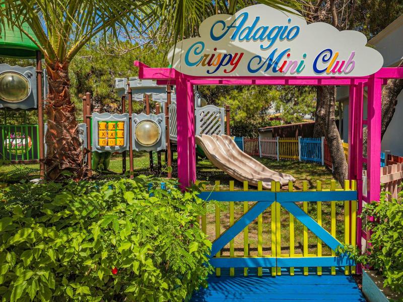 Colorido campo de minigolf con toboganes y mucha vegetación al aire libre bajo el sol.